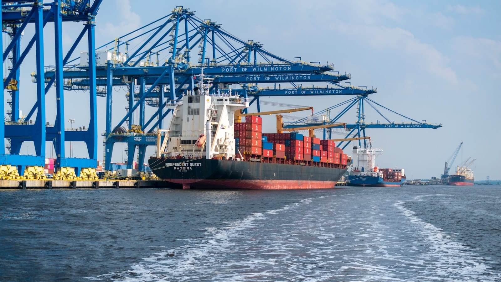 Porte-conteneurs quittant un terminal portuaire, portiques de chargement en arrière-plan